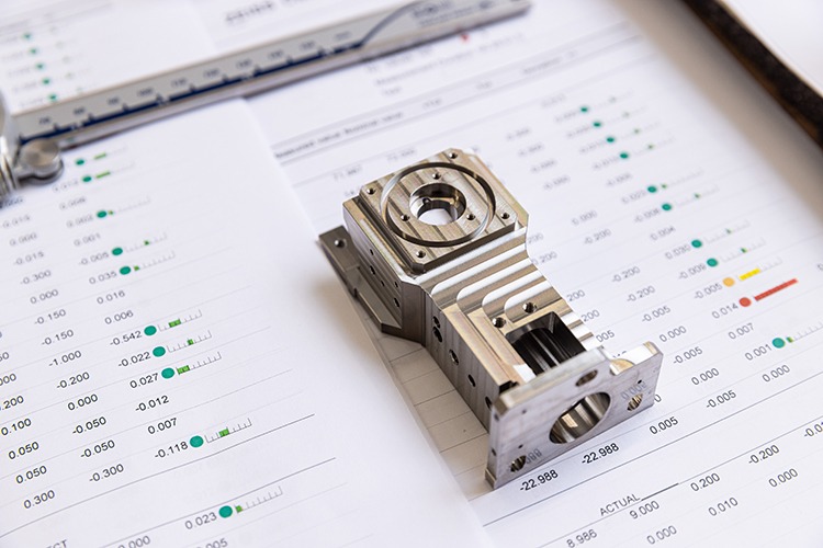 Precision aerospace component on measurement sheets, showcasing detailed machining data and specifications for quality assurance.