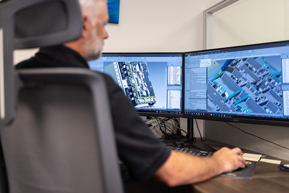 Manufacturing engineer Jeremy Fritchy at FK Instrument Co. using Mastercam CAD/CAM software on dual monitors for aerospace part design and machining optimization.