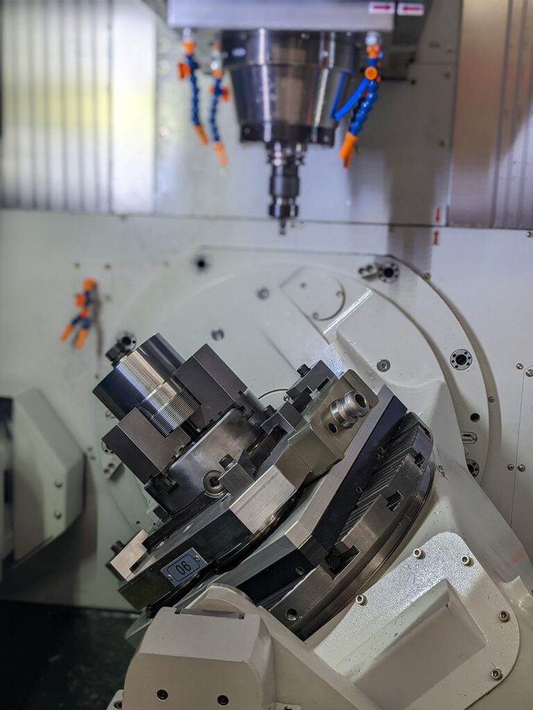 Doosan multiaxis CNC machine with a custom fixture holding a complex gear for precision machining, illustrating advanced CAD/CAM integration for manufacturing efficiency.