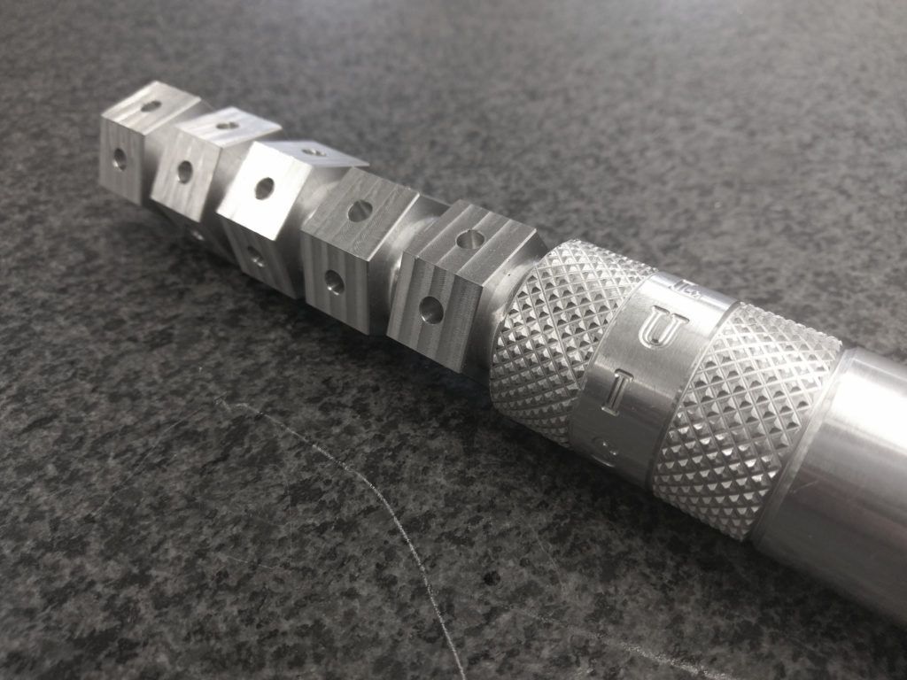 Aluminum CNC machined part with multiple drilled holes and contours, showcasing precision engineering for CAD/CAM programming in the Machine Technology Program at San Diego City College.