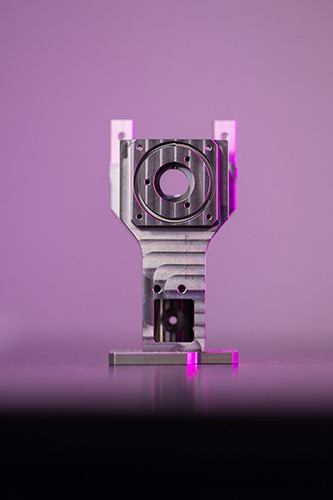 Precision aerospace component showcasing intricate machining details, featuring an 8µ angular tolerance and 5µ profile tolerance, highlighted against a subtle purple background.