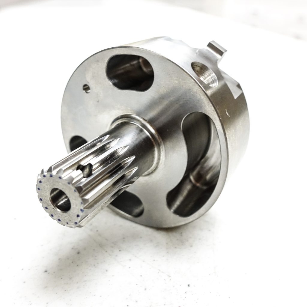 Machined metal part showcasing intricate design features, including a central shaft with splines and multiple openings, representing advanced CNC precision manufacturing for the Mazak Integrex III Series.